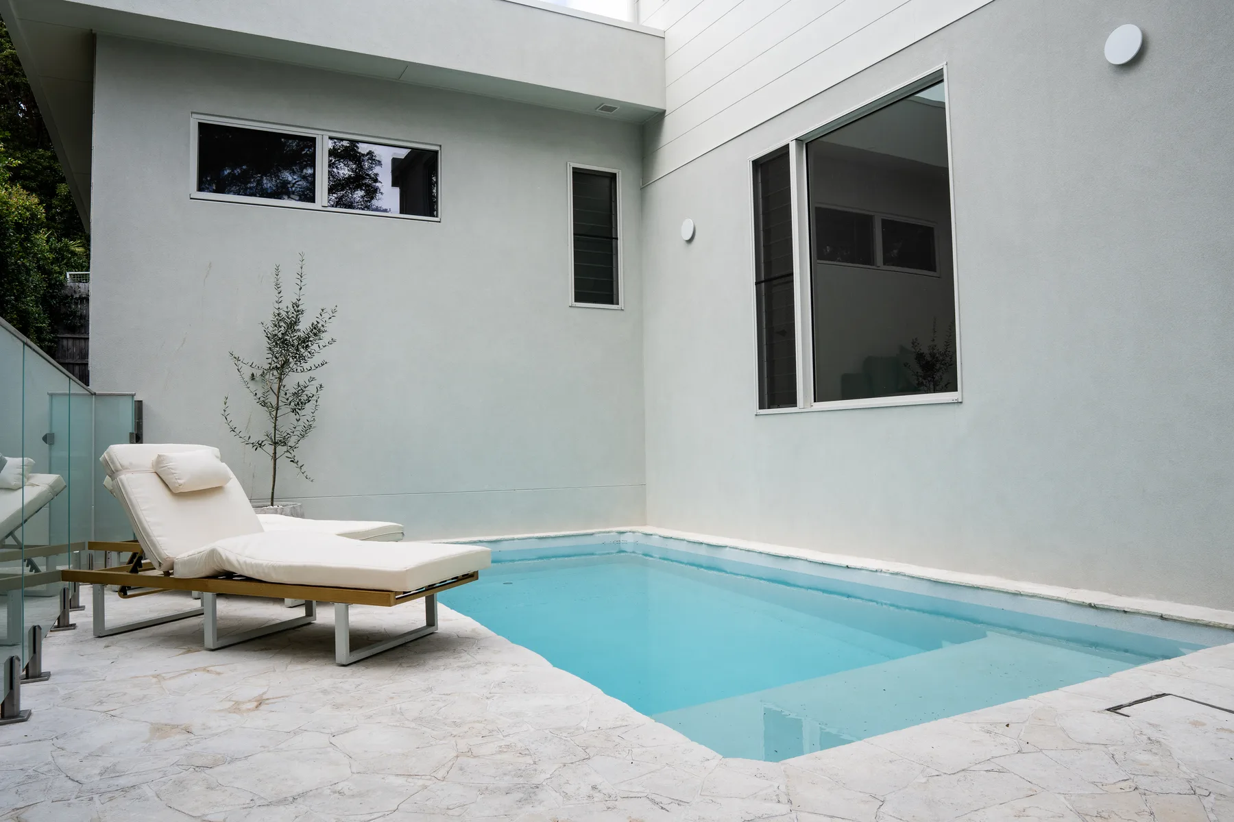 Freshly painted modern home exterior beside a swimming pool