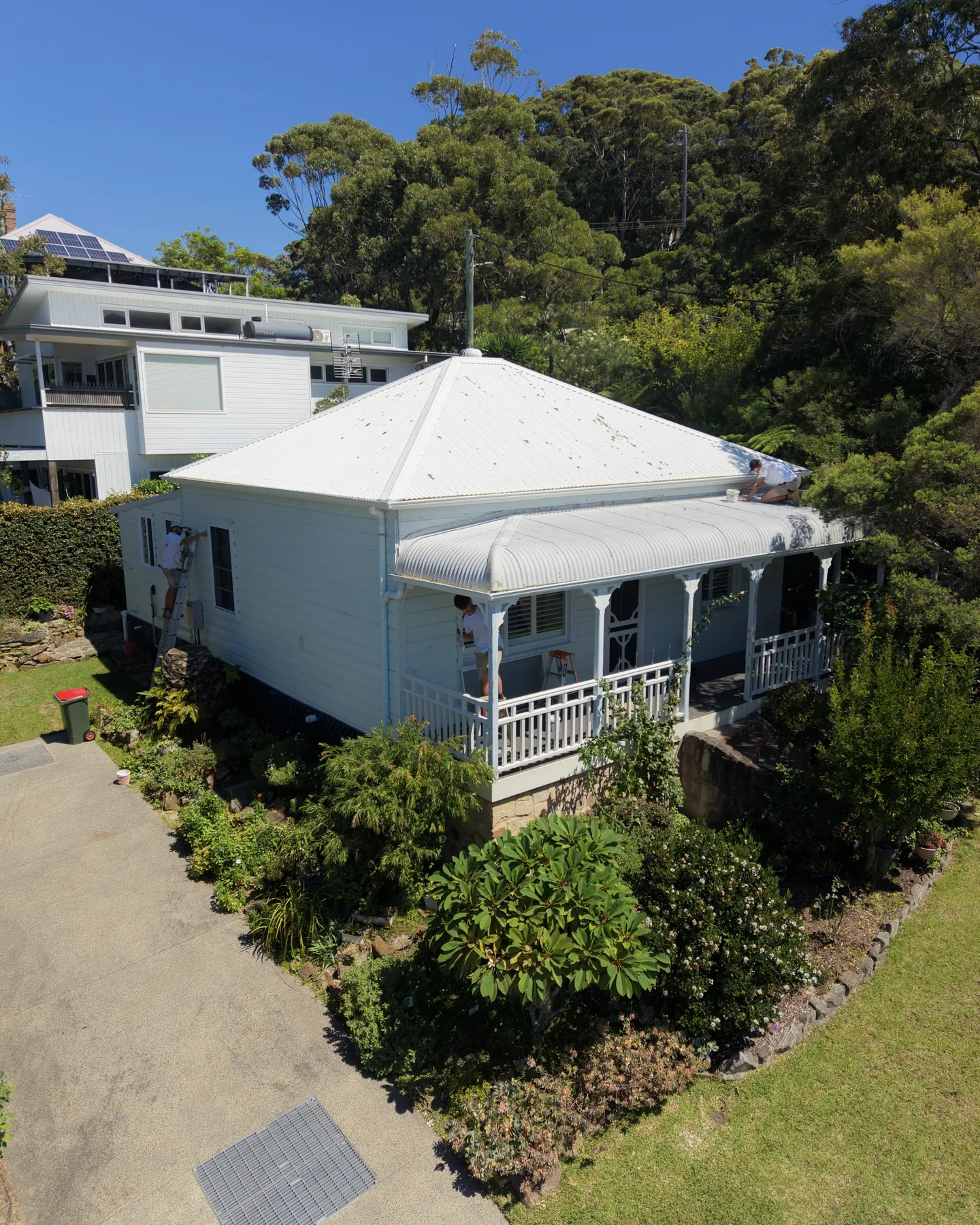 Aerial view of painters restoring a weatherboard home